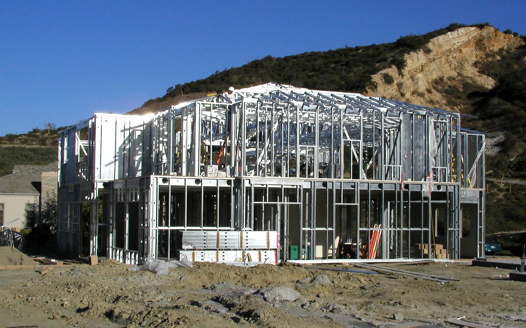 Two-story hillside residence under construction with cold-formed steel framing.
