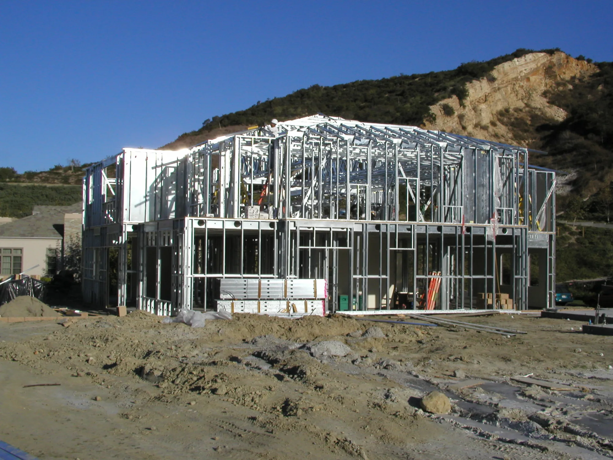 Full-house cold-formed steel framing on a hillside construction site