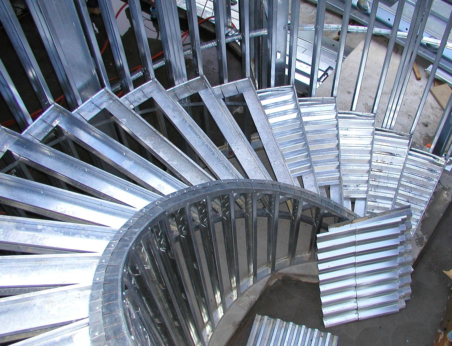 Curved residential stair structure framed in cold-formed steel.