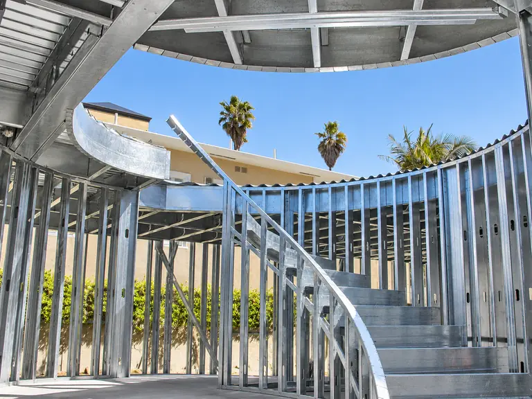 Interior cold-formed steel framing with curved geometry and a custom curved stair.