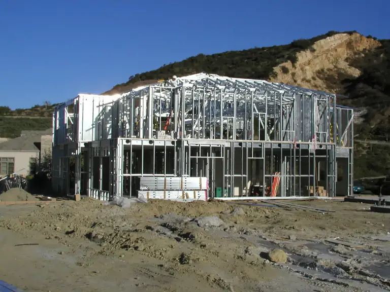 Full-house cold-formed steel framing on a hillside construction site