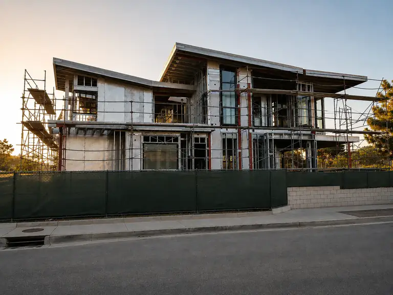 Two-story modern custom home framed in cold-formed steel, seen from the street during construction